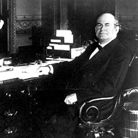 William Jennings Bryan, full-length portrait, seated at desk, facing left