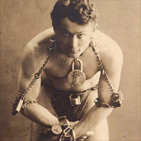 Harry Houdini, full-length portrait in chains.