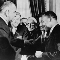 President Johnson gives King a pen he used to sign the bill into law. 詹森總統送給金恩一支他用於簽署該法案立法的筆 