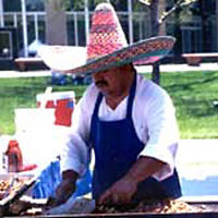 Photo of man wearing a sombrero at a grill