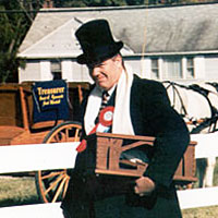 Photo man in period costume with hatchet in front of horse-drawn buggy