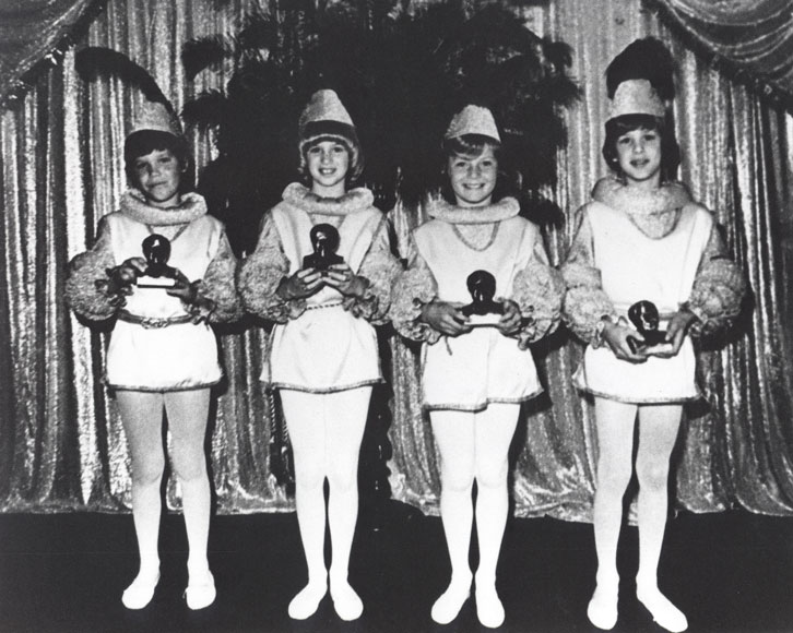 Photo of children on stage in costume holding busts of Edison