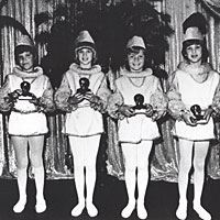 Photo of children on stage in costume holding busts of Edison