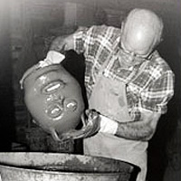 Photo of man dipping jug into bucket