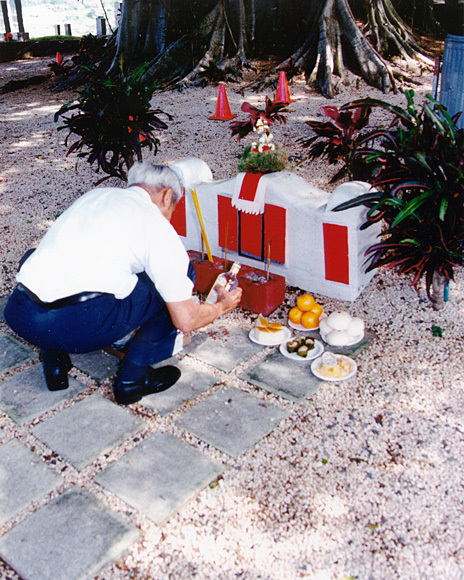 Photo of Tin Yau Yee honoring his ancestors by laying out foods on an ancestral grave