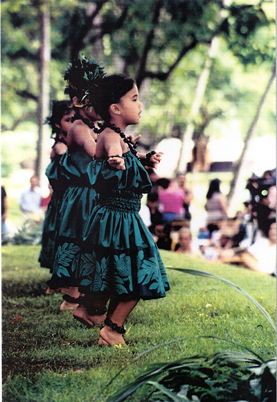 Photo of young hula dancers performing on the grass