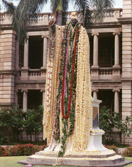 Photo of outdoor statue draped with leis