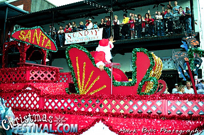 Photo of Santa waving to the crowd from a Christmas float