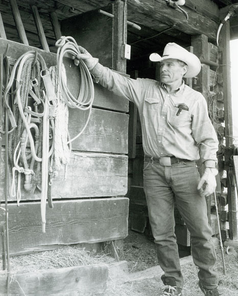 Photo of man in cowboy hat hanging up rope