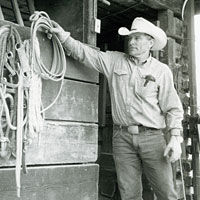Photo of man in cowboy hat hanging up rope