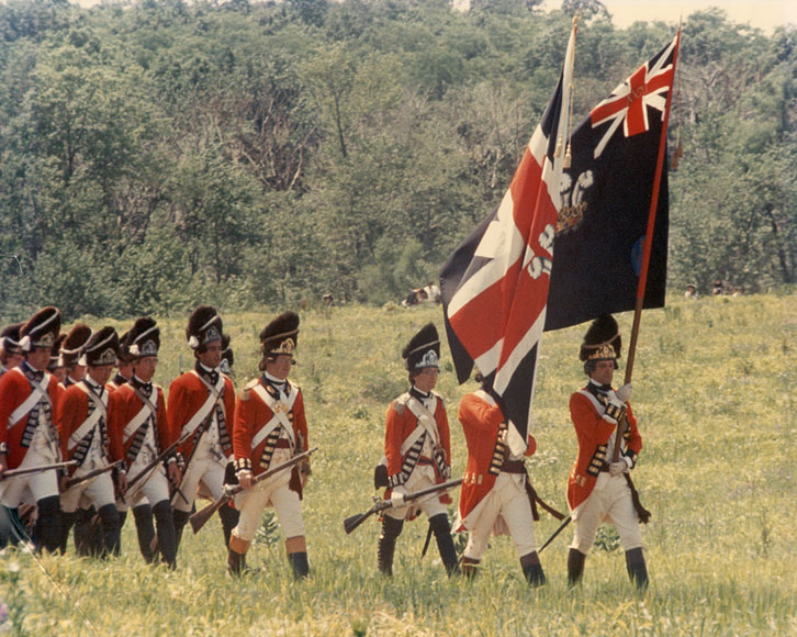 Photo of men in British uniforms marching with flags