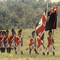 Photo of men in British uniforms marching with flags