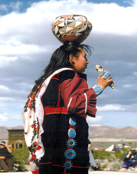 Photo of Zuni Olla woman in traditional clothing with a jar on her head