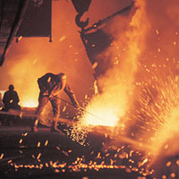 Photo of a person working in a steel mill with sparks flying