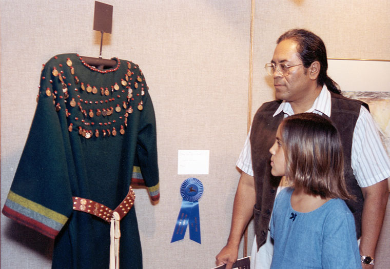 Photo of a man and a girl looking at a dress on display