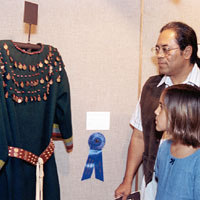 Photo of a man and a girl looking at a dress on display