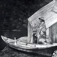 Photo of a fishing camp, boat, and two people