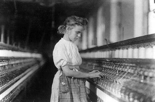 Portrait of a girl, standing, working at a machine in a textile plant, Cherryville, N.C.