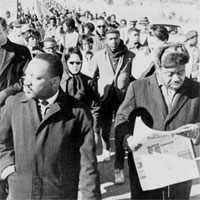 Rev. Ralph Abernathy walking with Dr. Martin Luther King, Jr., as they lead civil rights marchers out of camp to resume their march