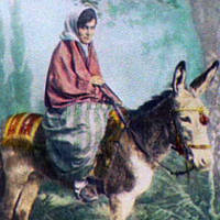 Young woman riding burro.