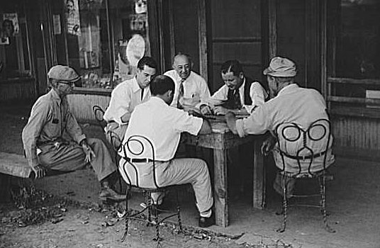 Playing dominoes or cards in front of drug store in center of town, in Mississippi Delta, Mississippi