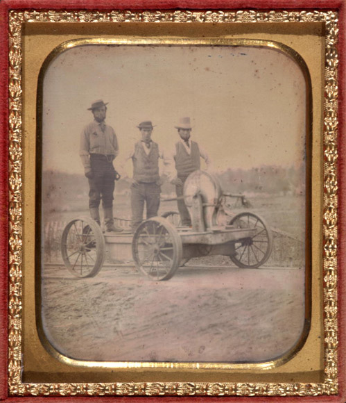 Occupational portrait of three railroad workers standing on crank handcar, between 1850 and 1860