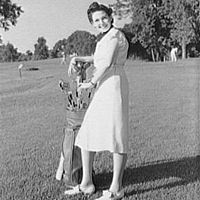 Woman with clubs on golf course