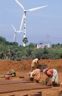 印度農婦在風力渦輪機下勞作。
