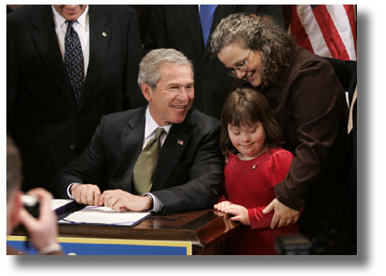 布希總統幾年來支援了數項有關殘疾人士的專案和法律。這張2004年的照片顯示他在簽署《殘疾人士教育法案》前，與一對母女交談。