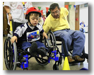  海岸警衛隊退役隊員、一級輪椅運動員在阿拉斯加安克雷奇舉行的輪椅運動會上幫助一名8歲男孩操控輪椅