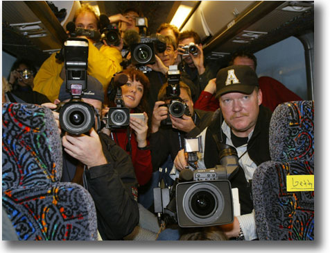 2004年1月在候選人乘坐大轎車在艾奧瓦州開展巡迴競選活動期間，記者團成員從新聞車上對候選人拍照和提問。