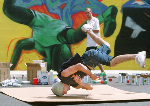 Taking a break from painting a hip-hop-themed mural on the wall of a Michigan youth center, this artist shows off his break-dancing moves