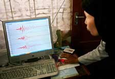 印度尼西亞班達亞齊地球物理站的一位技術人員正在分析數碼地震儀數據