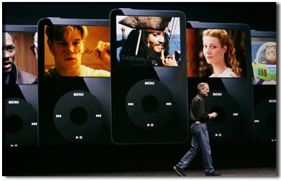 蘋果電腦公司首席執行官史蒂夫·喬布斯走在巨型模擬iPods播放器前，上面放映著不同影片的片段。2006年9月，蘋果公司推出在線影片服務，方便人們在家裡或路上看電影。