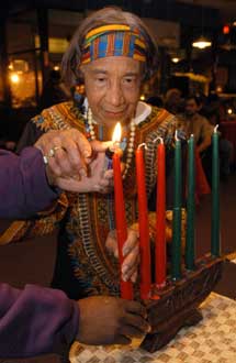 麻塞諸塞州布羅克頓市88高齡的蒂娜·所羅門，在非洲裔美國人的寬紮節首夜點燃一枝蠟燭。