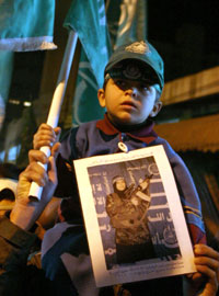 在2004年支持哈馬斯的一次集會上，一名巴勒斯坦男孩手持
一幅一名在以色列和加沙地帶之間一個主要交界點引爆炸彈的婦女的照片。有四人在爆
炸中喪生。