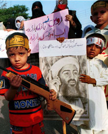 在巴基斯坦伊斯蘭大會黨(Jamat-e-Islami)於卡拉奇組織的一
次集會上，巴基斯坦男孩手持玩具槍和本·拉登的畫像。