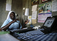 Nongovernmental organizations work worldwide. Here, a Uganda aid worker uses a solar-powered computer provided by an American NGO.