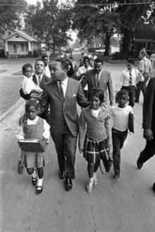 Civil rights leader Martin Luther King Jr., leading black children to all-white schools in Mississippi in 1966. Dr. King became the public face of the 『60s civil rights movement; he was later assassinated.