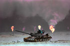在油井火海旁的一輛被擊毀的伊拉克坦克