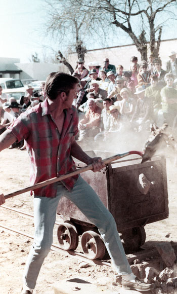 Photo of man participating in the Mucking Contest, n.d.