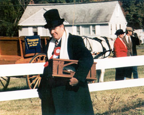 Photo man in period costume with hatchet in front of horse-drawn buggy