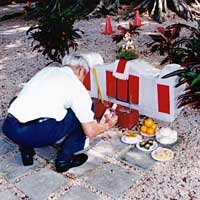 Photo of Tin Yau Yee honoring his ancestors by laying out foods on an ancestral grave