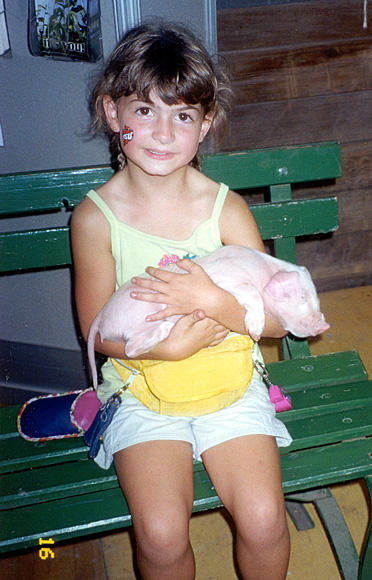 Photo of girl holding baby pig