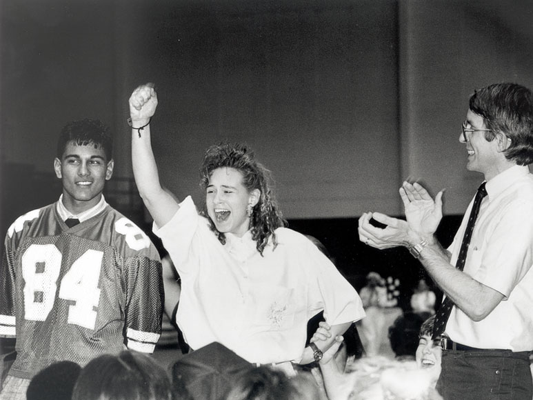 Photo of woman raising her arm while people clap