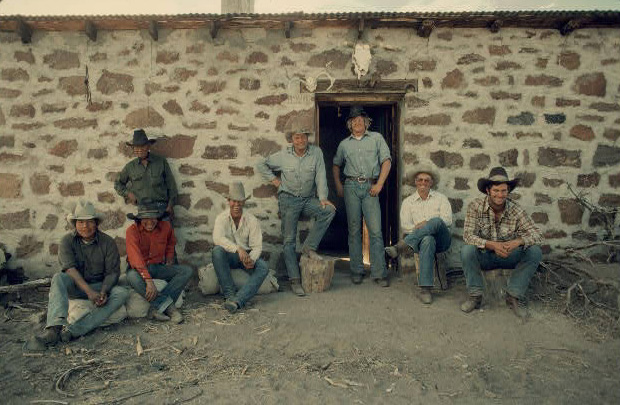 Buckaroos resting in front of a cabin