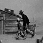 A farmer and his sons walk in a dust storm in Oklahoma in 1936.