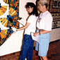 Photo of two women looking at labels on displayed quilts