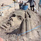 Photo of a sand sculpture of King Neptune's head and hand