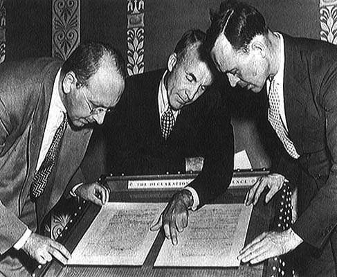 September 1944, Librarian of Congress Archibald MacLeish, center, joined Reference Department director David C. Mearns and Verner W. Clapp of the Acquisitions Department.